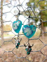 Load image into Gallery viewer, Hydrangea And Cow Skull Teal Heart Earrings

